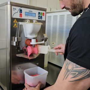 Άνδρας φτιάχνει παγωτό σε μηχανή.