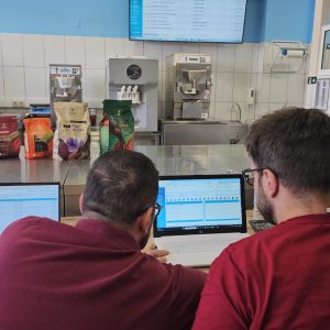 Δύο άτομα σε καφετέρια, εργάζονται.