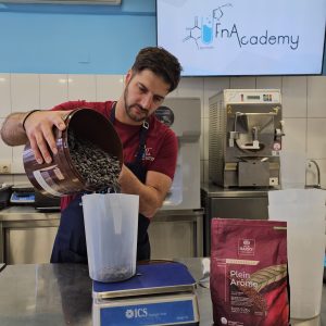 Ρίχνει καφέ σε δοχείο μέτρησης.